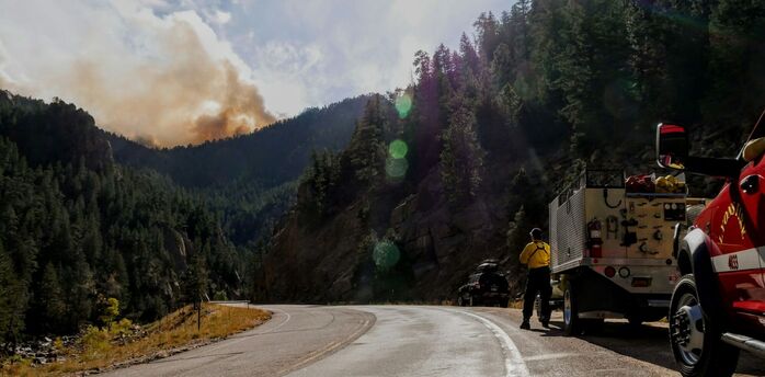 Fire crews monitoring smoke near a mountain road