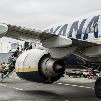 Passengers board a Ryanair aircraft on the apron
