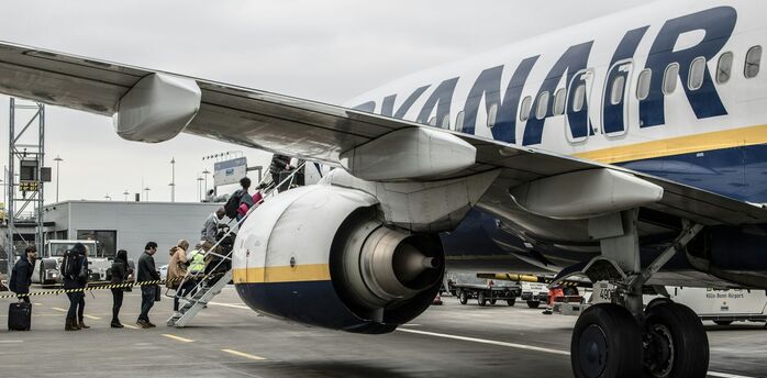 Passengers board a Ryanair aircraft on the apron
