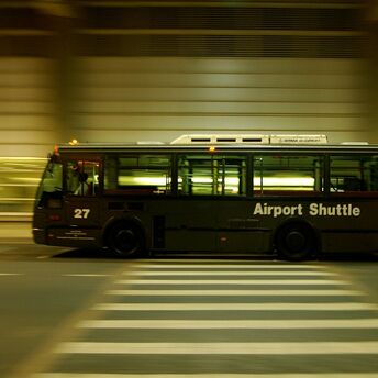 Airport shuttle bus travelling beside a terminal