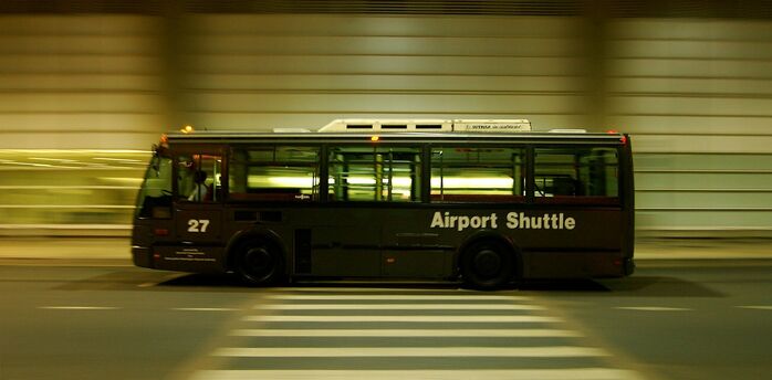 Airport shuttle bus travelling beside a terminal