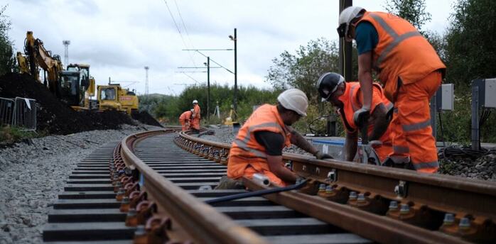 Rail workers renewing railway track