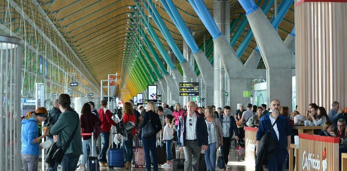 Passengers inside a busy Spanish airport terminal