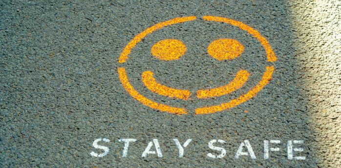 Stay safe message painted on pavement