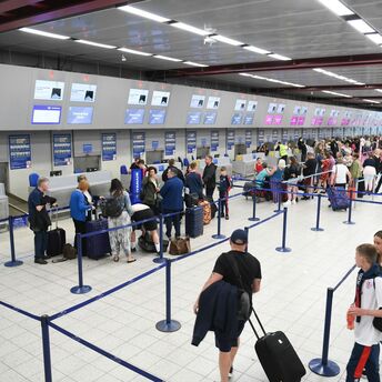 Passengers queuing at airport check-in desks