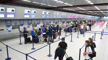 Passengers queuing at airport check-in desks