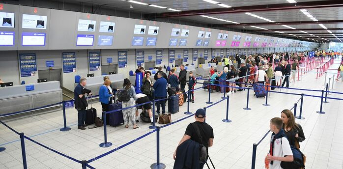 Passengers queuing at airport check-in desks