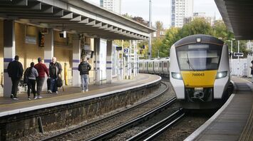 Passengers beside a commuter train at a UK station