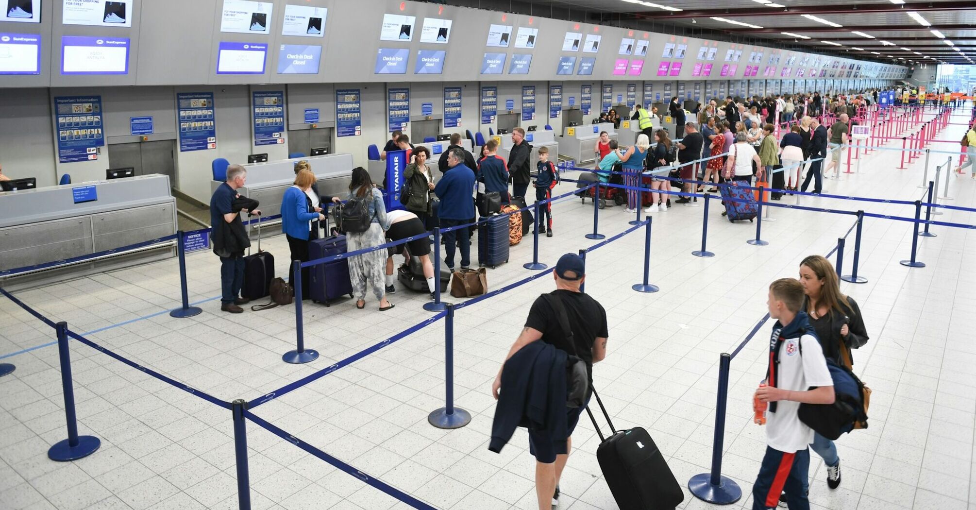 Passengers queueing at airport check-in desks
