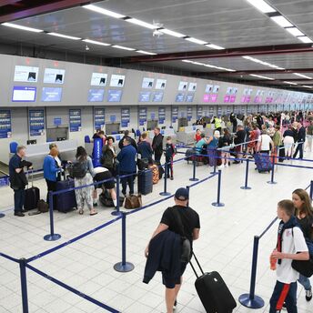 Passengers queueing at airport check-in desks