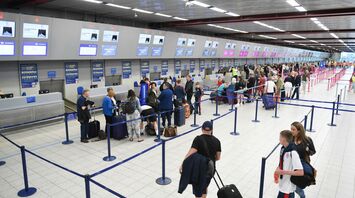Passengers queueing at airport check-in desks