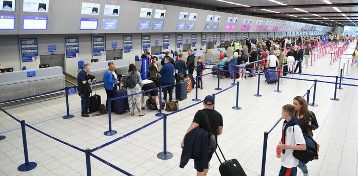 Passengers queueing at airport check-in desks